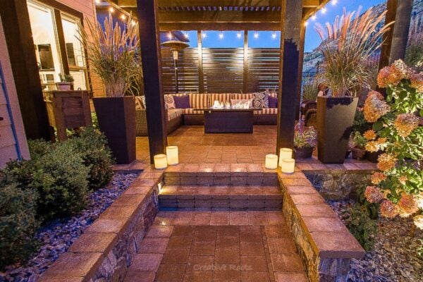 Outdoor seating area with soft landscape lighting reflecting a warm, personalized design in Kelowna